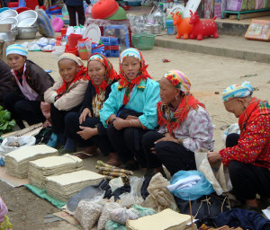 Dzao women selling shaman paper, shovel blades, nuts, and incense.