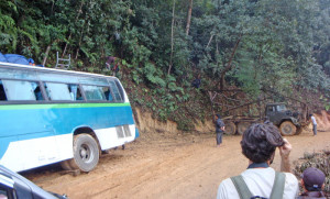 The bus in the ditch from the slippery road, and the towtruck men in the trees bracing the truck for pulling on the bus.