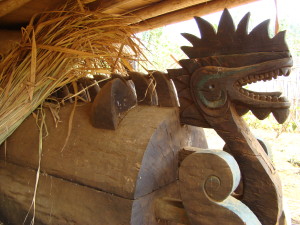 A Katu coffin in Laos made in the shape of a Naga (mythical river serpent) is stored under a rice storage shed until needed.