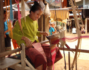 Weaver cutting a scarf off her loom for us.
