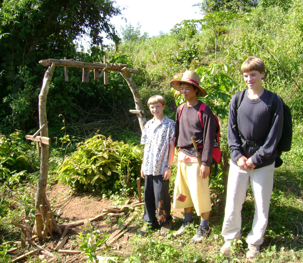 Zall, Tui, and Ari in front of an Akha village spirit gate.