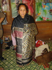 Phout's aunt, Sukkhavit, dons a shaman's traditional healing cloth; this one is not of the "man-woman" style.